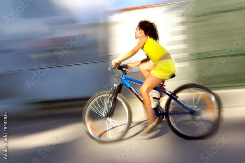 Photo of a young girl riding a bicycle very fast