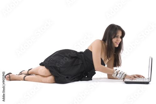 Smiling girl surfing in internet lying on the floor