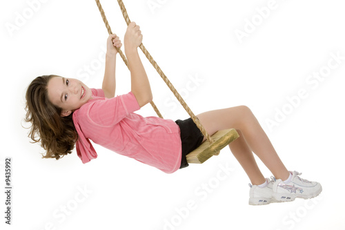 Caucasian child playing on a swing on white background