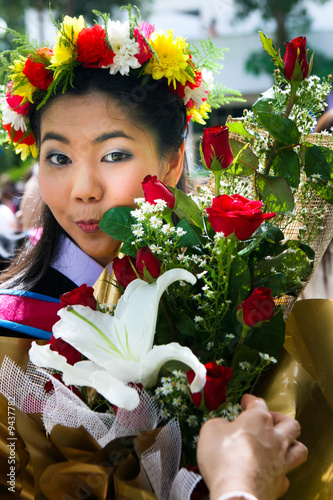 Beautiful young Asian graduate in robes on graduation day. photo