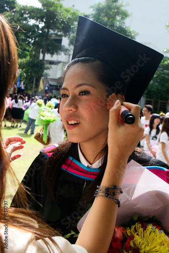 Beautiful Asian graduate having her make-up done. photo