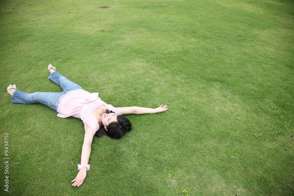 young woman lies on a lawn