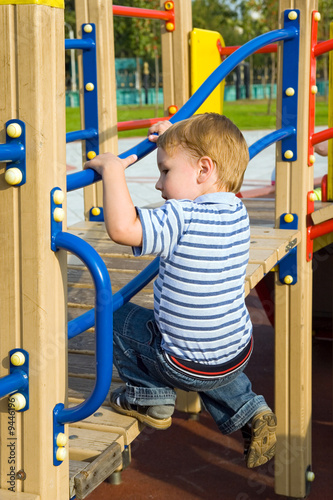 The boy climb on the equipment of a playground