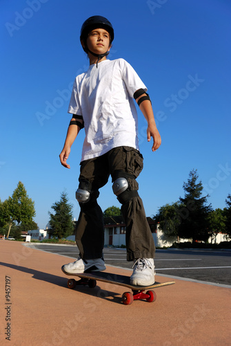 Boy on a Skateboard Against Blue Sky Looking in the Sun