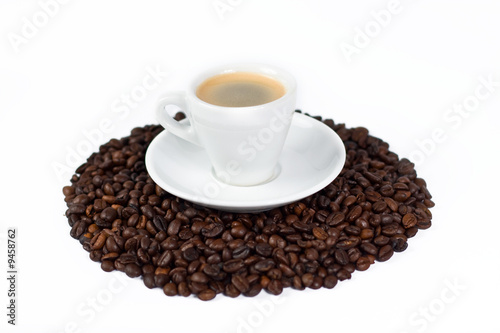 a cup of coffee on top of coffee beans