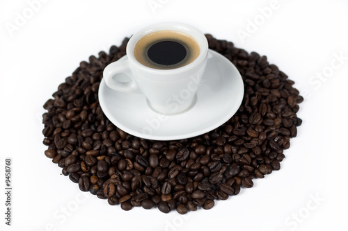 a cup of coffee on top of coffee beans