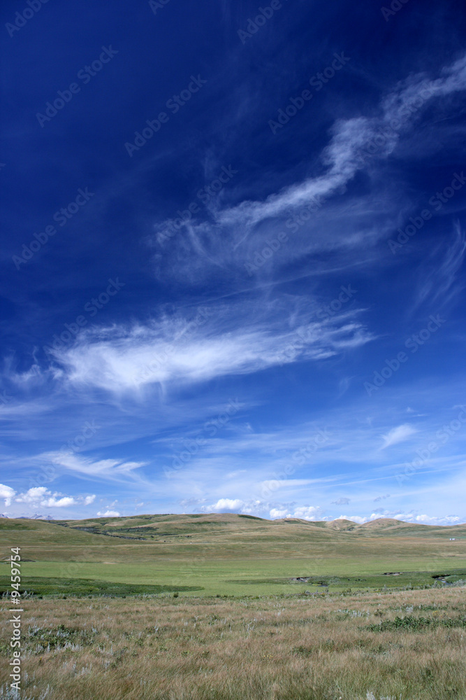 Rural fields landscape with fantastic white clouds, blue sky.