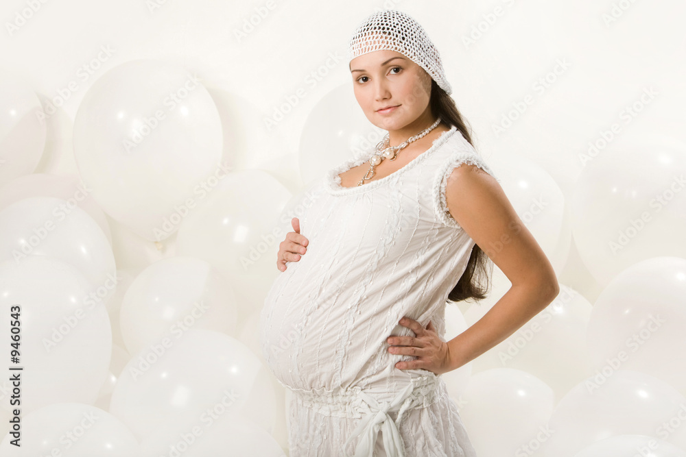 Ffashionable pregnant woman touching her belly