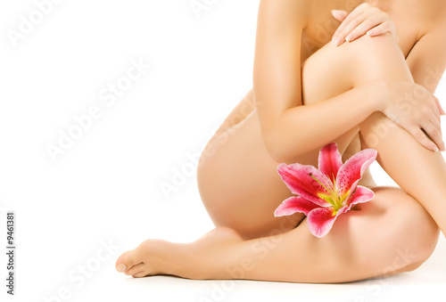 Female legs with pink lily isolated on white background
