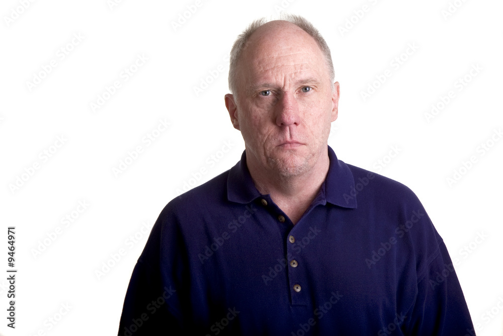 An older bald guy in a blue shirt with a serious expression An older bald guy in a blue shirt with a serious expression