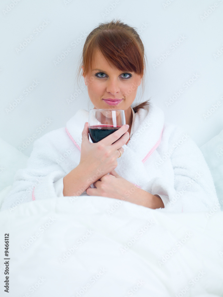 Beautiful woman eating drinking wine in bed