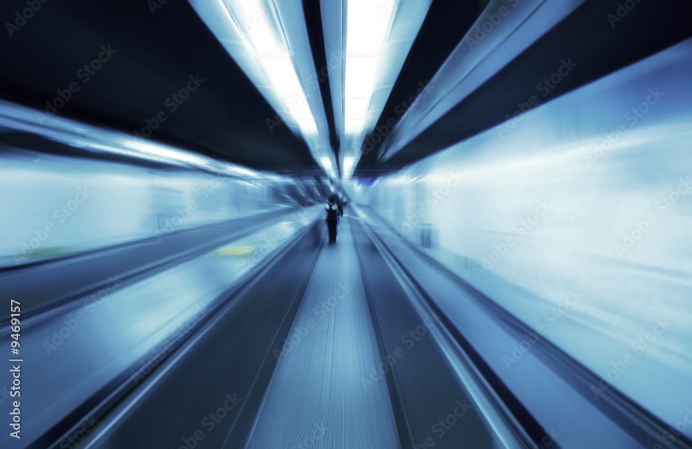 People travelling on a travolator walkway late at night