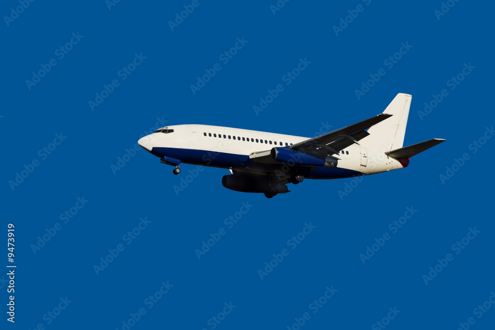 Fototapeta premium passenger jet in flight clear blue sky landing gear down