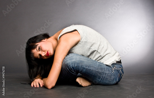 The dark-haired girl sitting on a floor it was bent forward