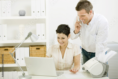 Happy couple working at home using laptop computer