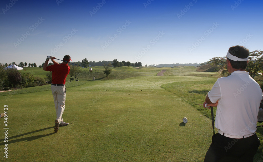 golfers hitting ball on the first tee