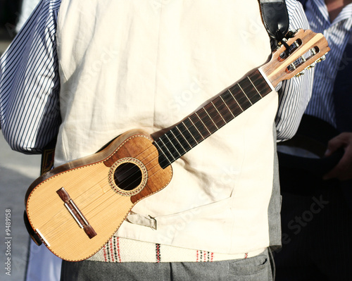 canarian man carrying traditional timple (small violin) photo