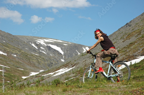 Girl biking in high mountains.