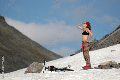Girl with a bike in high mountains.