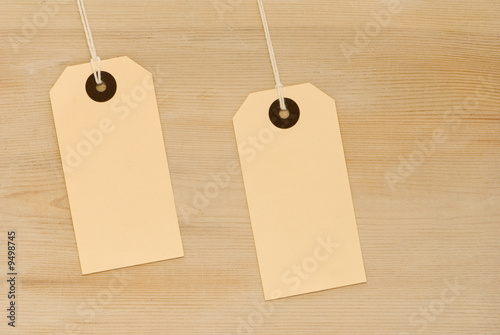 Two swing tags on wooden board background photo