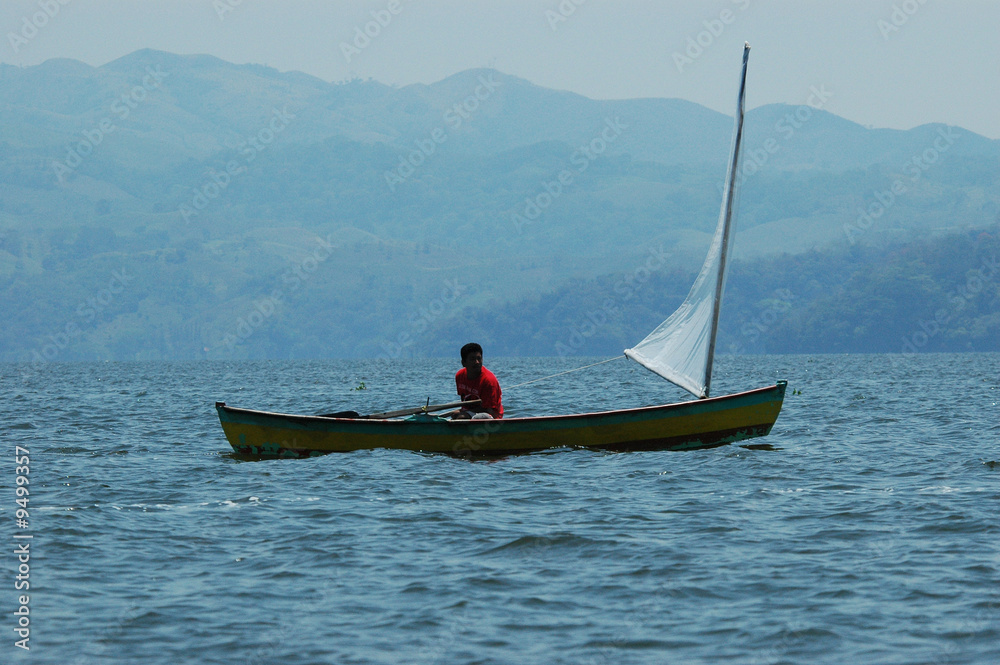 A fisher with his boat sailing near coast