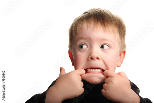 Cute young boy making a funny face, isolated on white