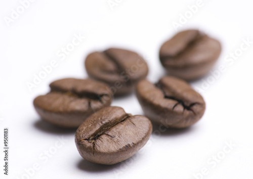 Close up of group of coffee beans on white background
