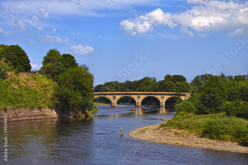 An angler on a  bend in the river Tweed near Coldstream, Scotland photo