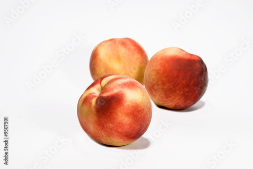 three ripe fresh peaches over white background