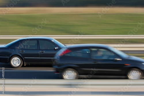 Fast car on a highway overtaking another one