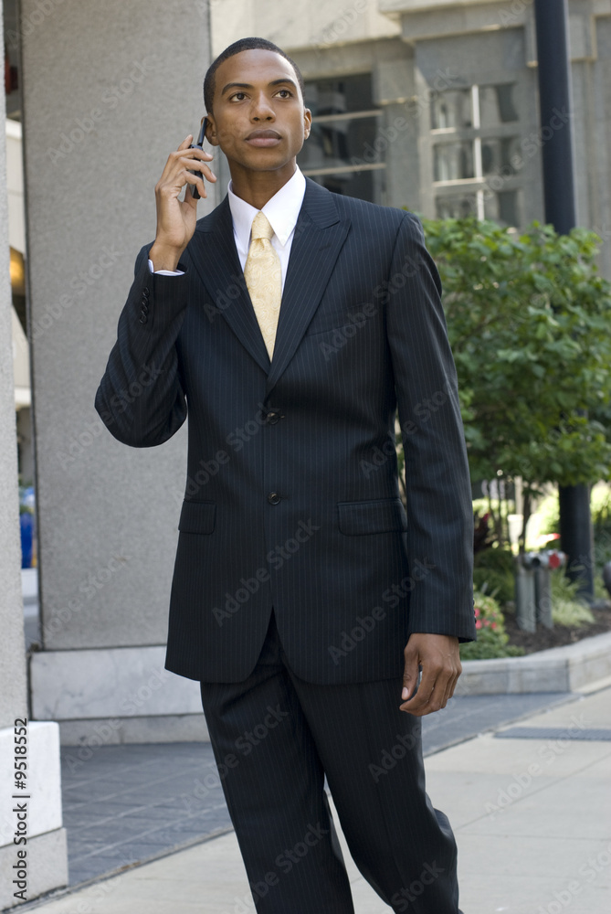 African-American model walking and talking on a cell phone African-American model walking and talking on a cell phone