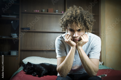 Young Brazilian teenager sad and upset in bedroom.