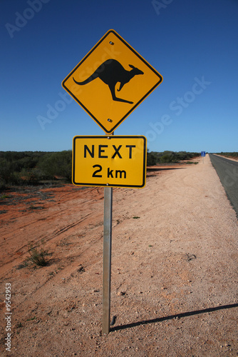Yellow kangaroo 2 km sign, empty roads of Australia