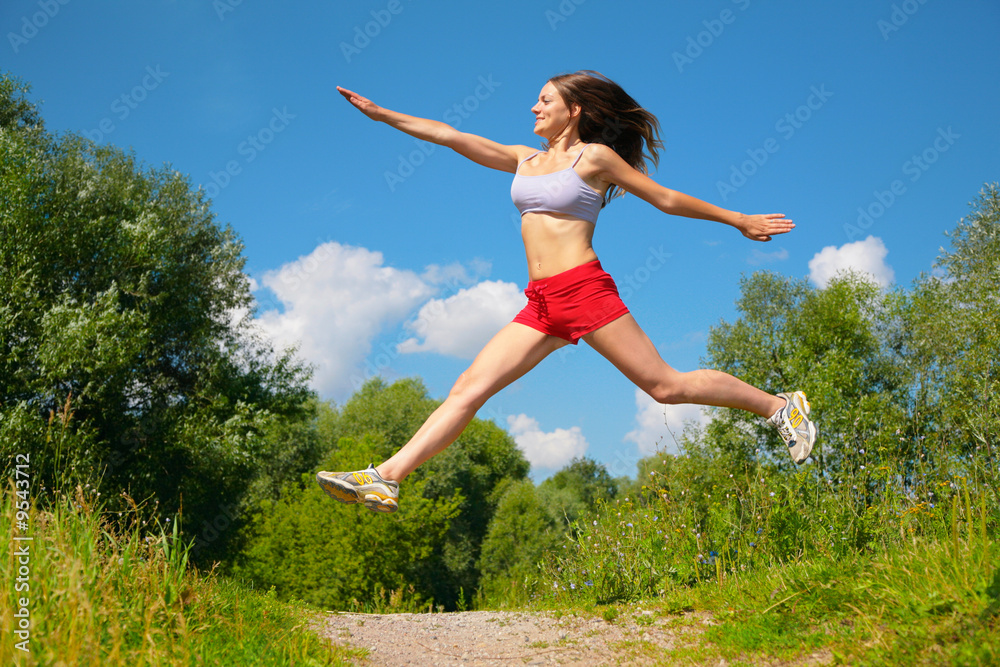 Young woman jumping doing exercise in park Young woman jumping doing exercise in park