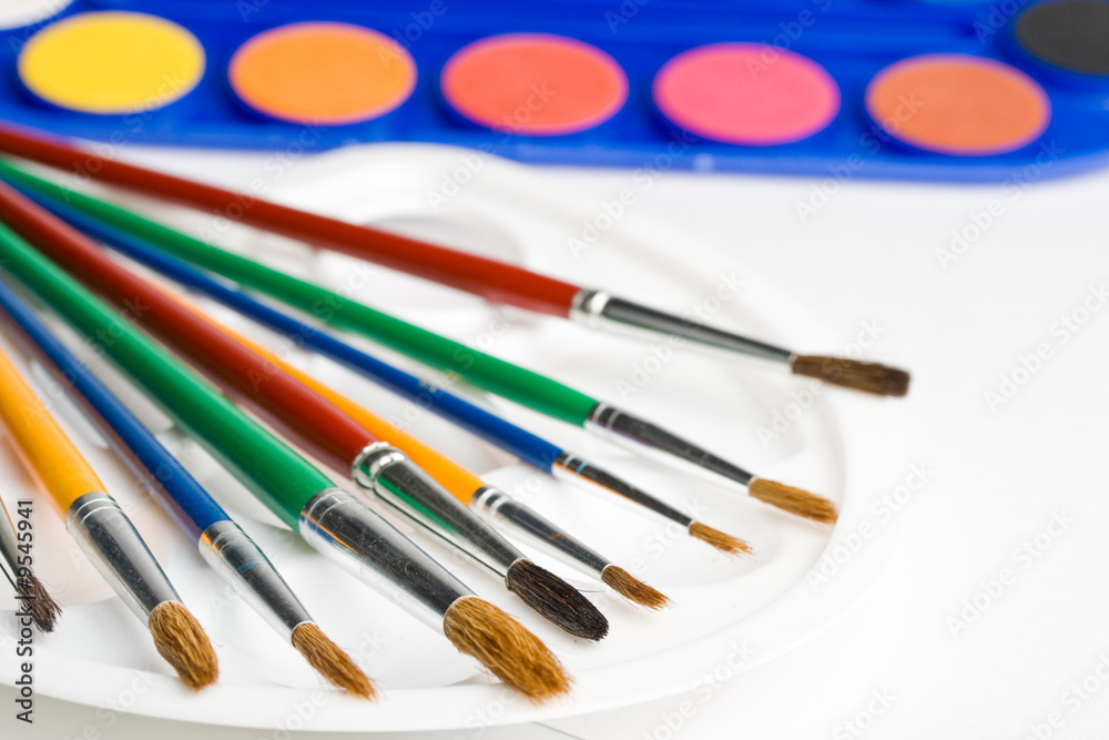 Obraz premium Water colour paints and brushes on a white background