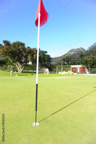 A professional golfer playing a shot out of a sand-trap.