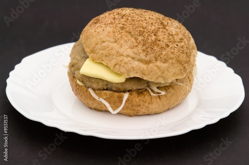 Sandwich on a white plate on a black background