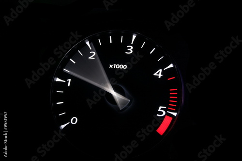 moving revs meter of a sports car on a black background.