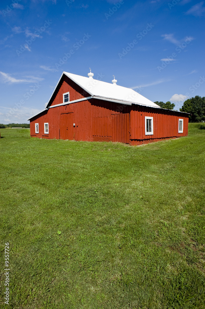 A freshly painted red barn on a green meadow