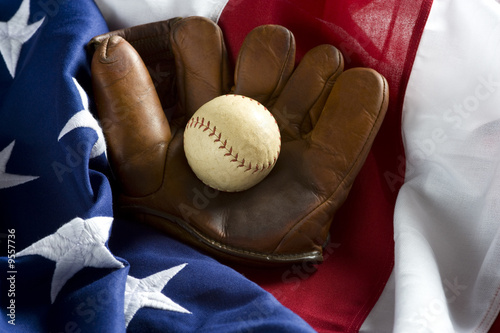 an antique glove baseball on top of an American Flag