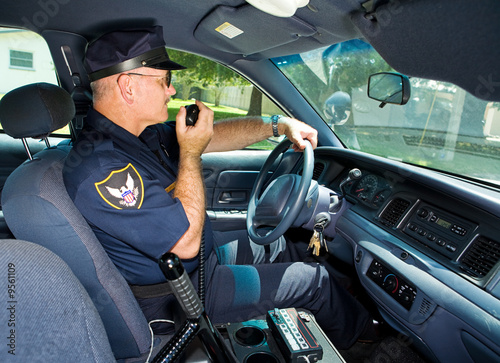 Police officer in his squad car, talking on his radio. photo