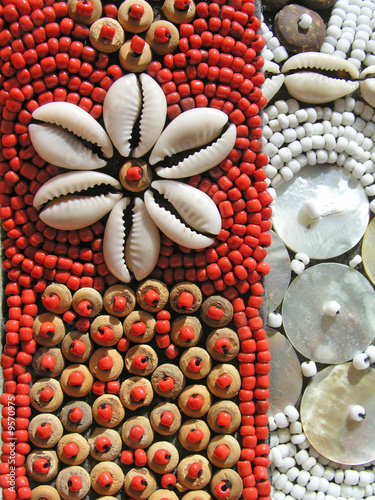 Details of beadwork with shells on red base