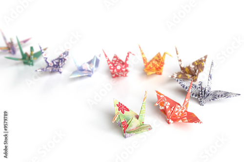 A queue of colourful origami birds on a white background