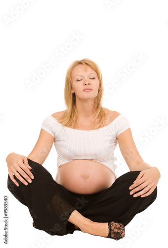 pregnant woman in lotos pose on a white background