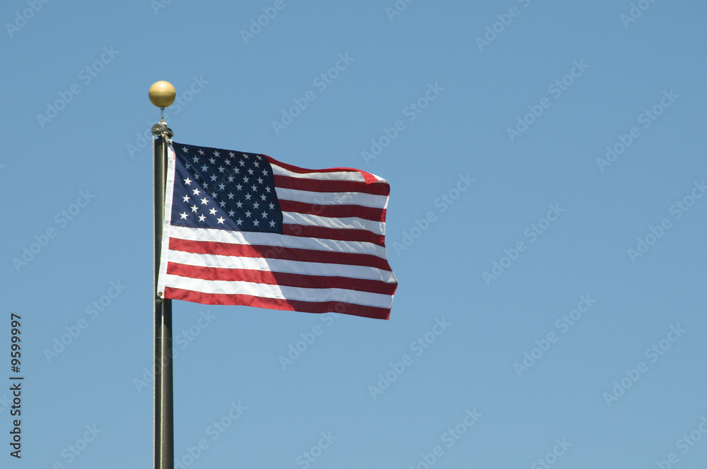 United Sates flag waving against a clear blue sky United Sates flag waving against a clear blue sky