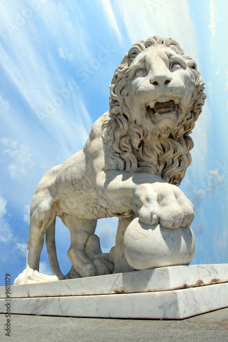 lion statue with ball over cloudy sky © Olexandr Kulichenko
