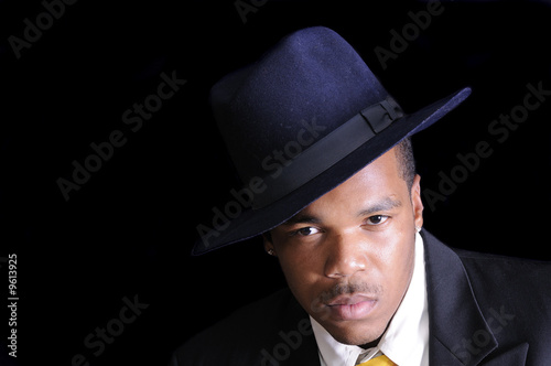 young African American man in a hat and suit