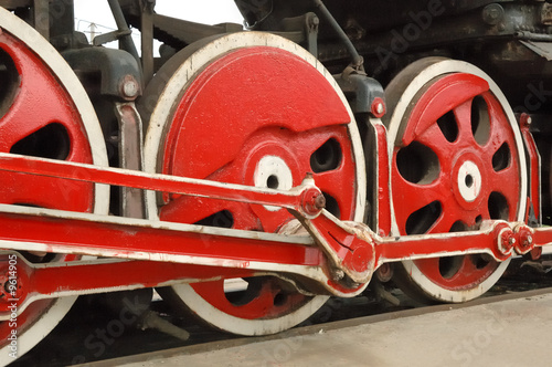 A close-up view of several big wheels from a very old locomotive