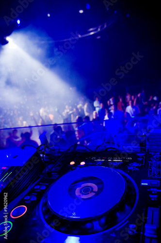 Dj’s turntable, blurred crowd on the background
