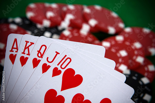 Fotografie, Obraz Cards with poker arrangement and poker chips in the background.